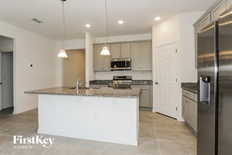 a kitchen with a large island and stainless steel appliances