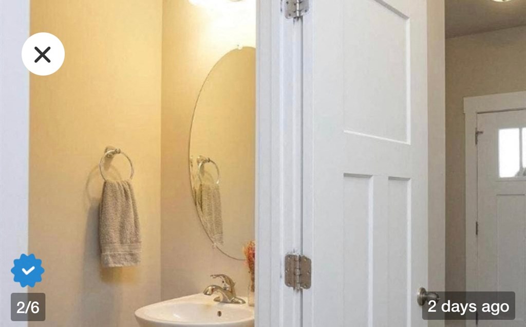 a bathroom with a sink and a mirror and a door