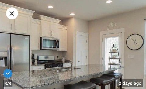 a kitchen with a granite counter top and a refrigerator