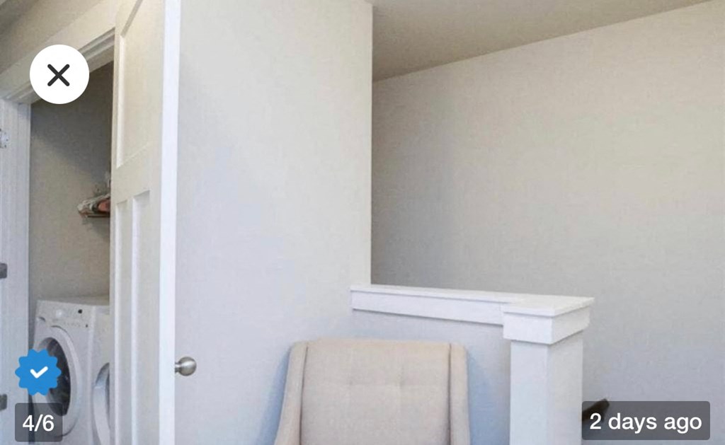 a laundry room with a white chair and a washing machine