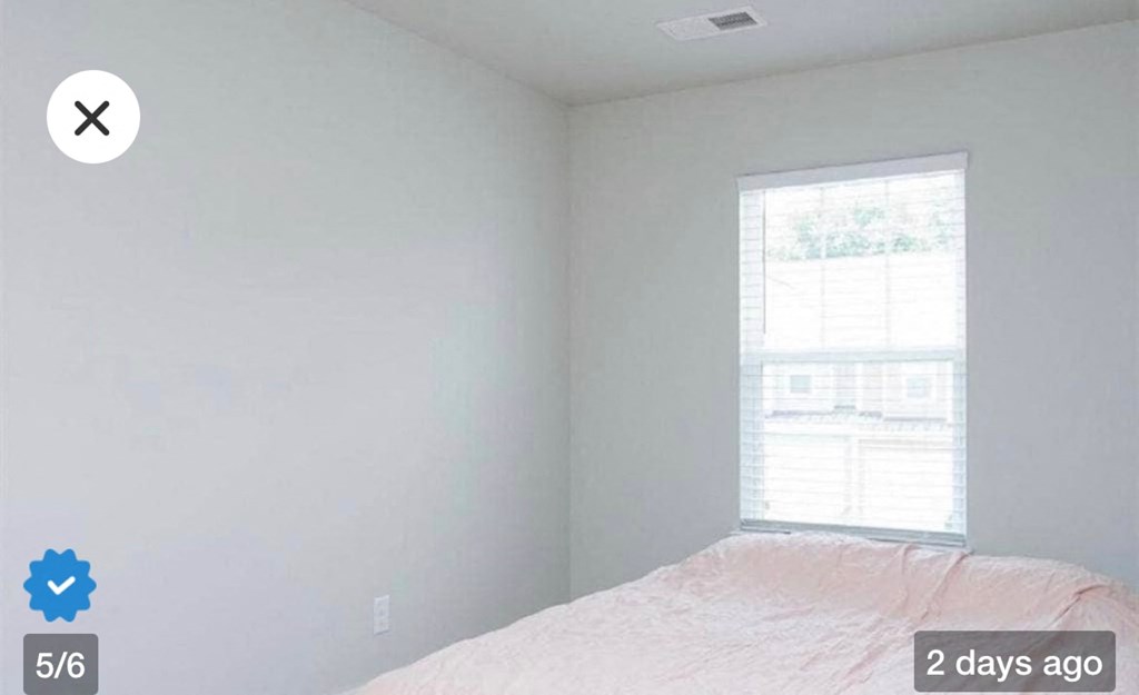 an empty bedroom with a bed and a window