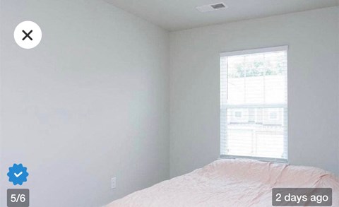 an empty bedroom with a bed and a window