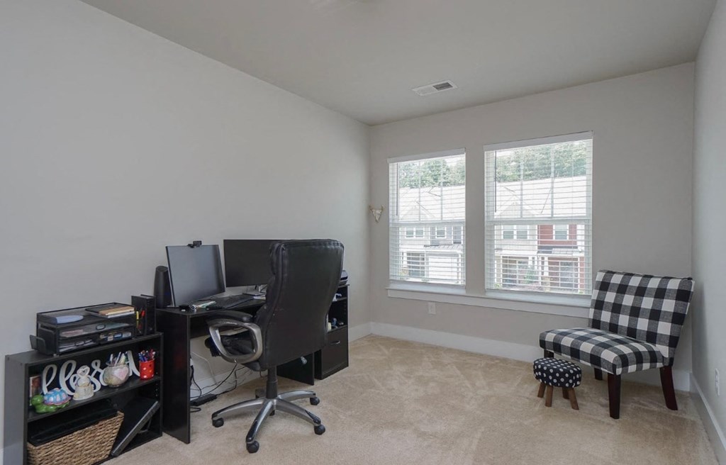 a home office with a desk and a chair and a window