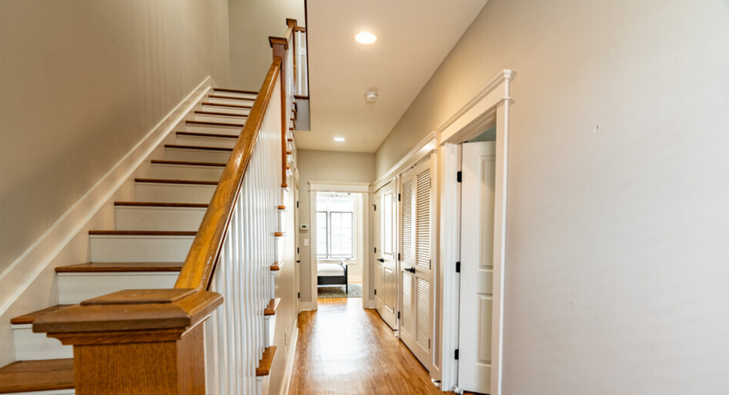 a staircase in a house with white walls and wood floors