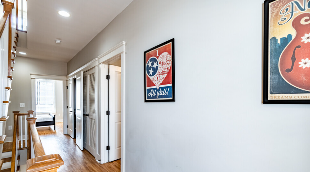 a hallway with a poster on the wall and a staircase