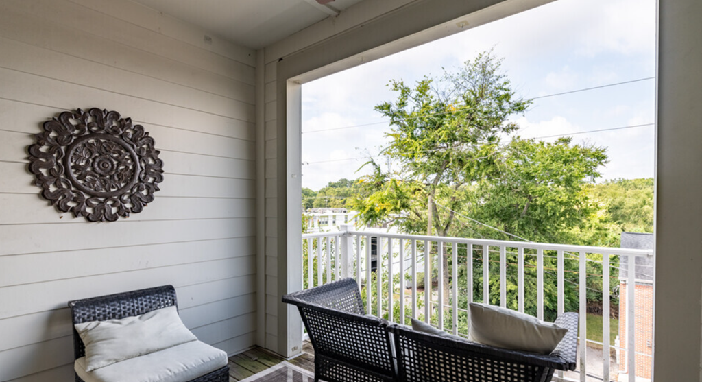 a porch with a table and chairs and a large window