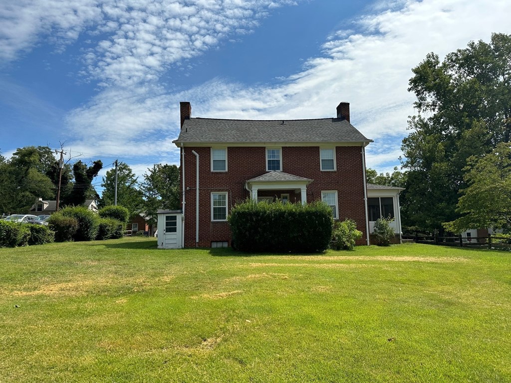 a red brick house with a green lawn in front of it