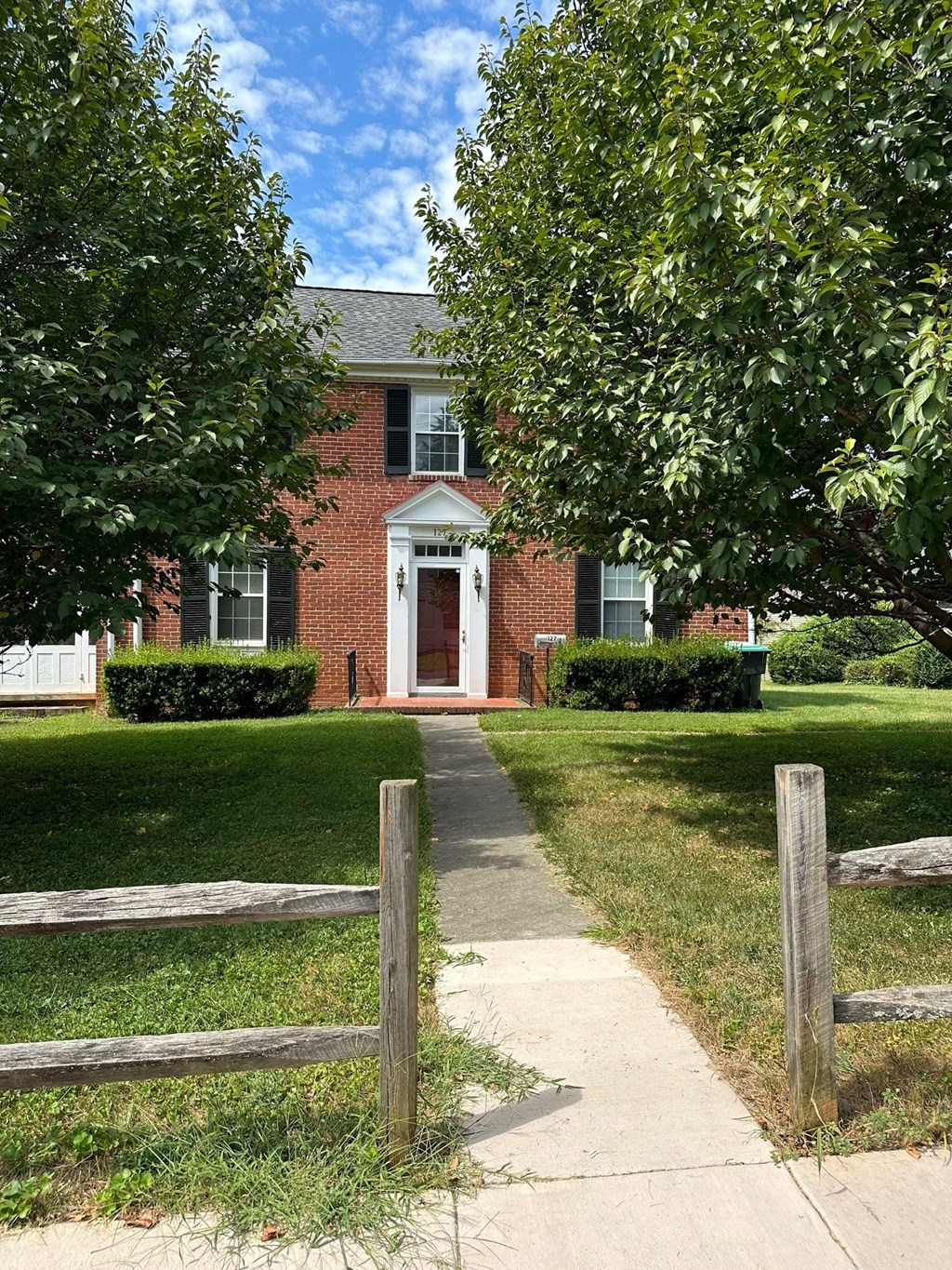 a sidewalk in front of a brick house