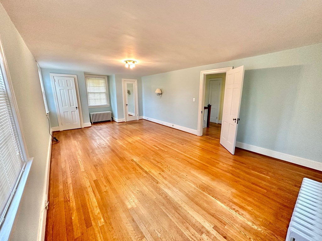 an empty living room with a hard wood floor