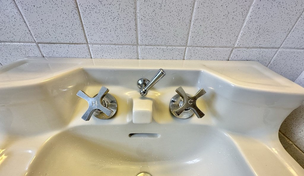 a bathroom sink with three different faucets on it