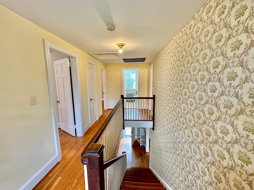 the entryway of a house with wallpaper and a staircase