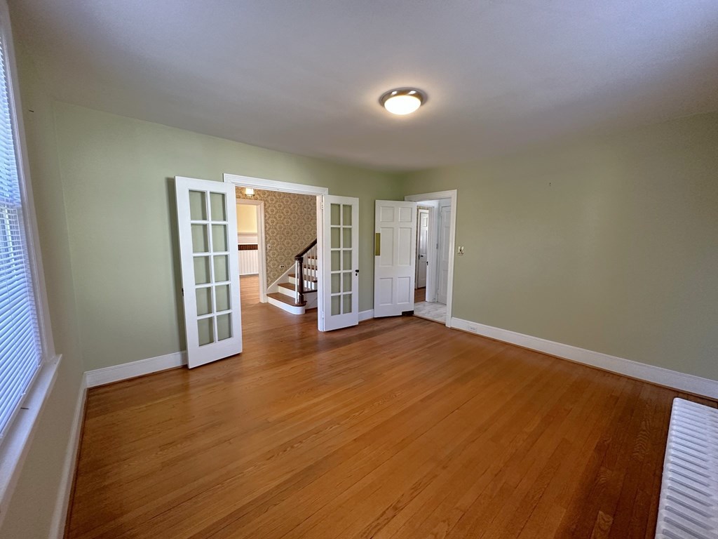 an empty living room with wood floors and green walls