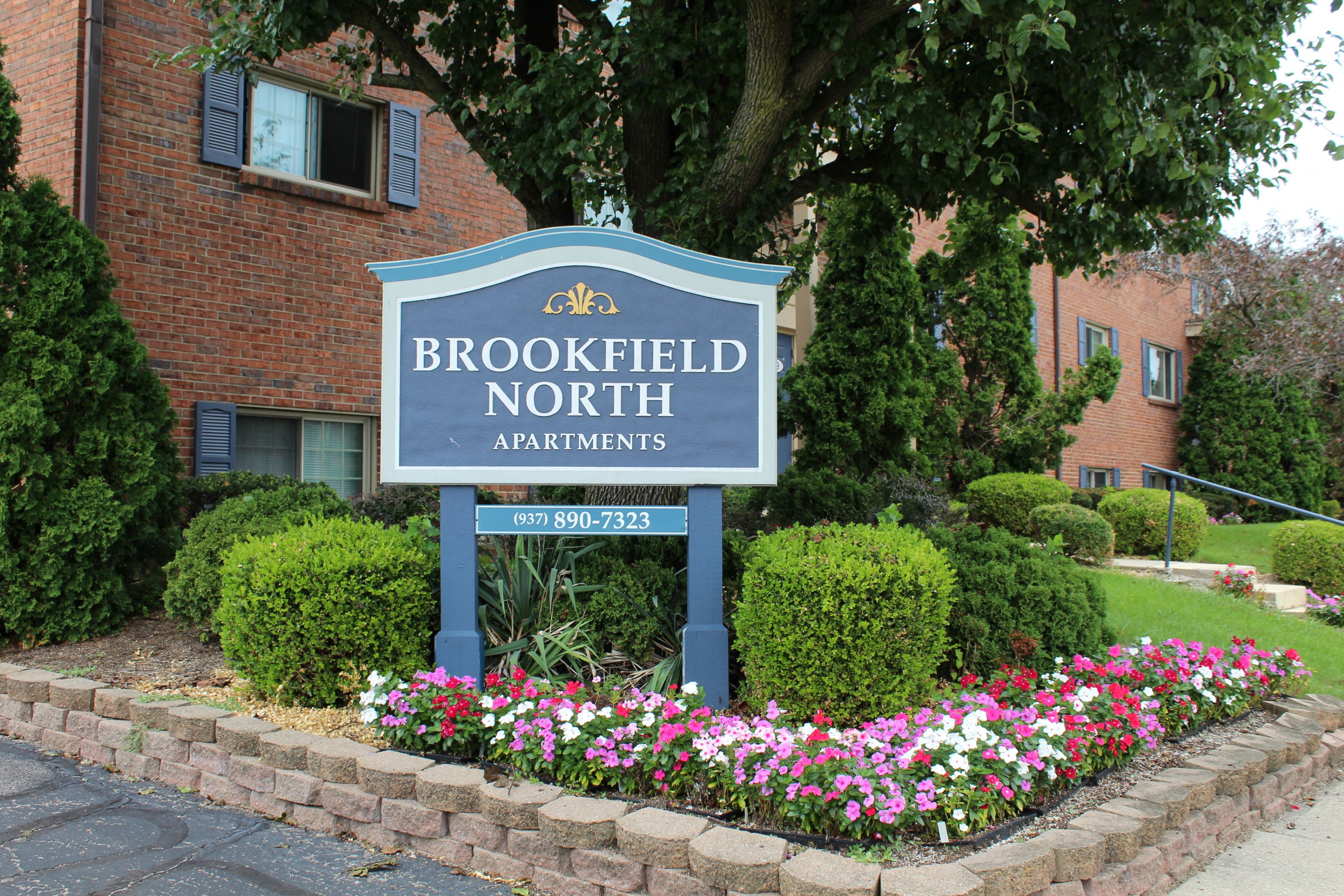a sign apartments in front of flowers