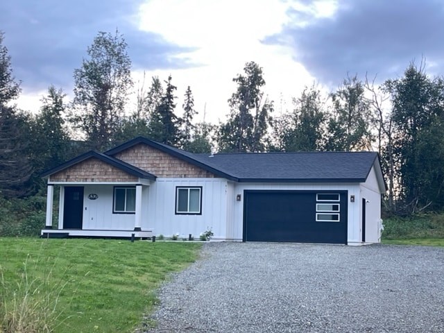 a white house with a garage and a gravel driveway