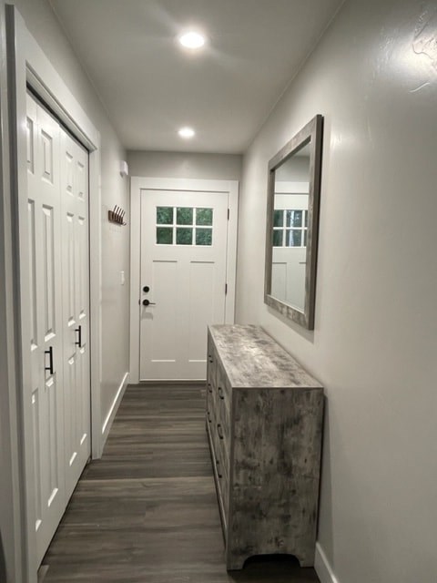 a hallway with a dresser and a white door