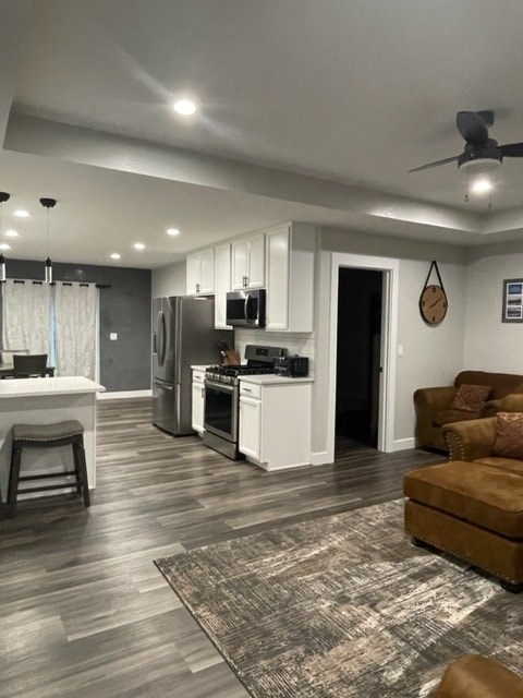 a kitchen and living room with a refrigerator and a sink
