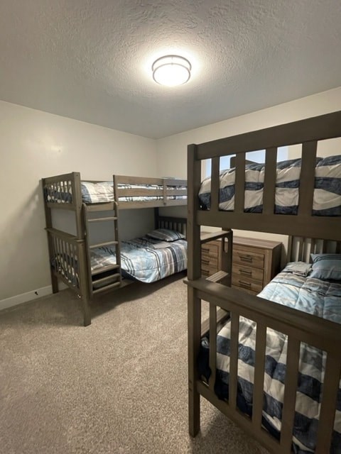 a bunk bed room with three bunk beds and a lamp