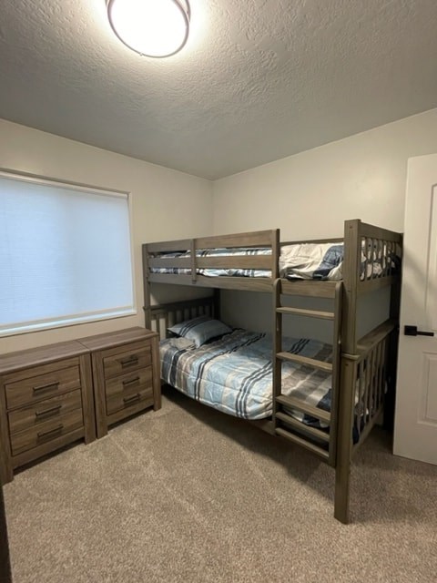 a bunk bed in a room with a window and a dresser