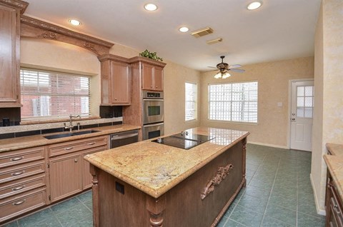 A kitchen with wooden cabinets and a granite countertop.