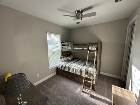 a bedroom with a bunk bed and a ceiling fan