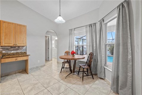 a dining room with a table and chairs next to a window