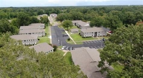 An aerial view of a parking lot and buildings surrounded by trees.