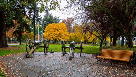 A park with cannons and a bench.