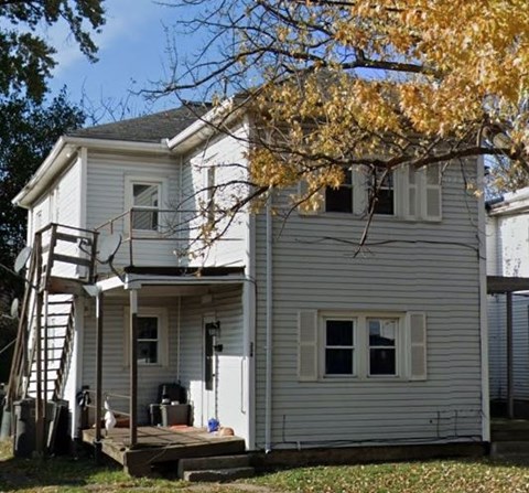 a white house with a tree in front of it