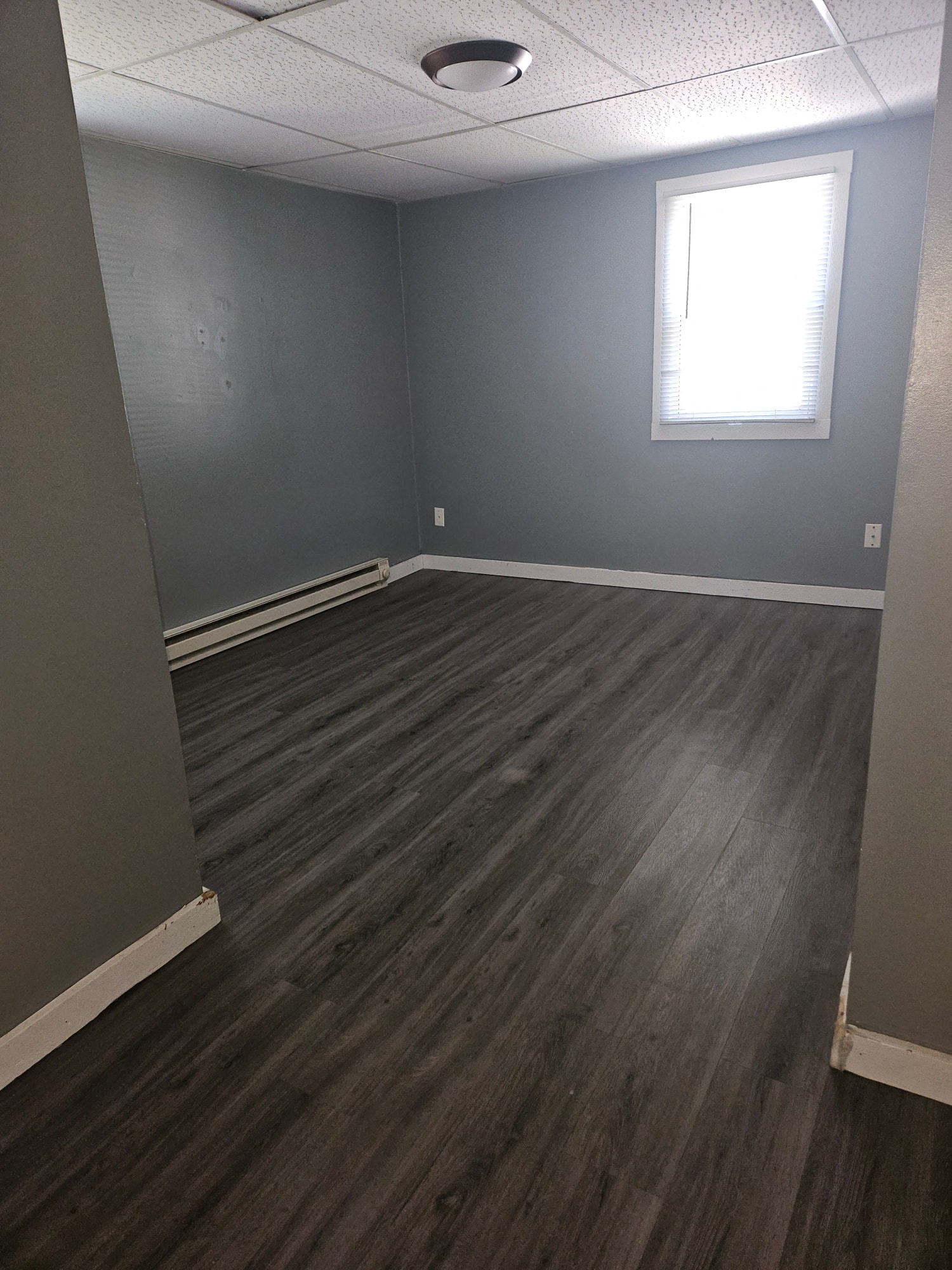 an empty room with wooden floors and a window
