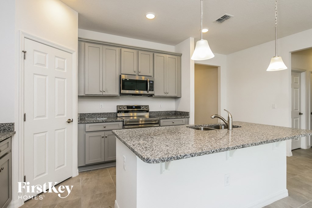 a kitchen with white cabinets and a granite counter top