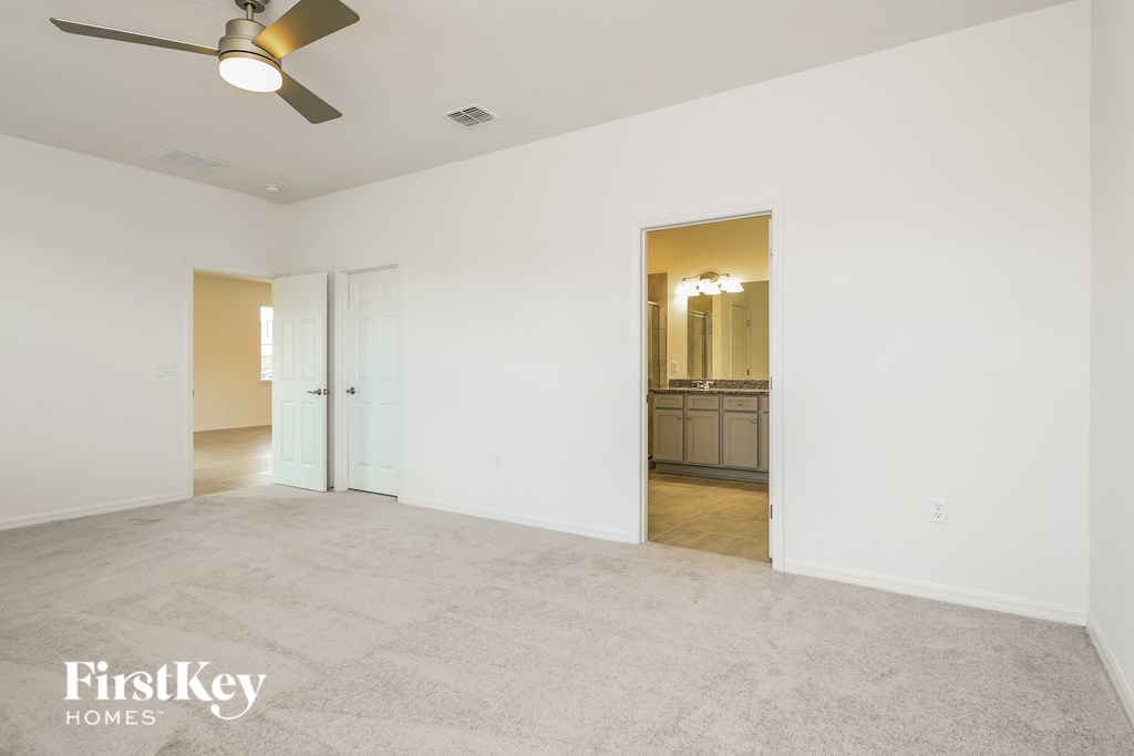 the living room and dining room of an empty house with a ceiling fan
