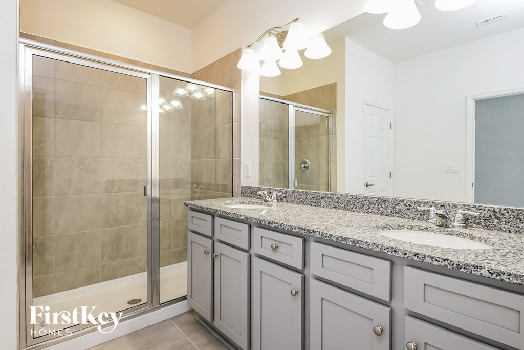 a bathroom with two sinks and a shower