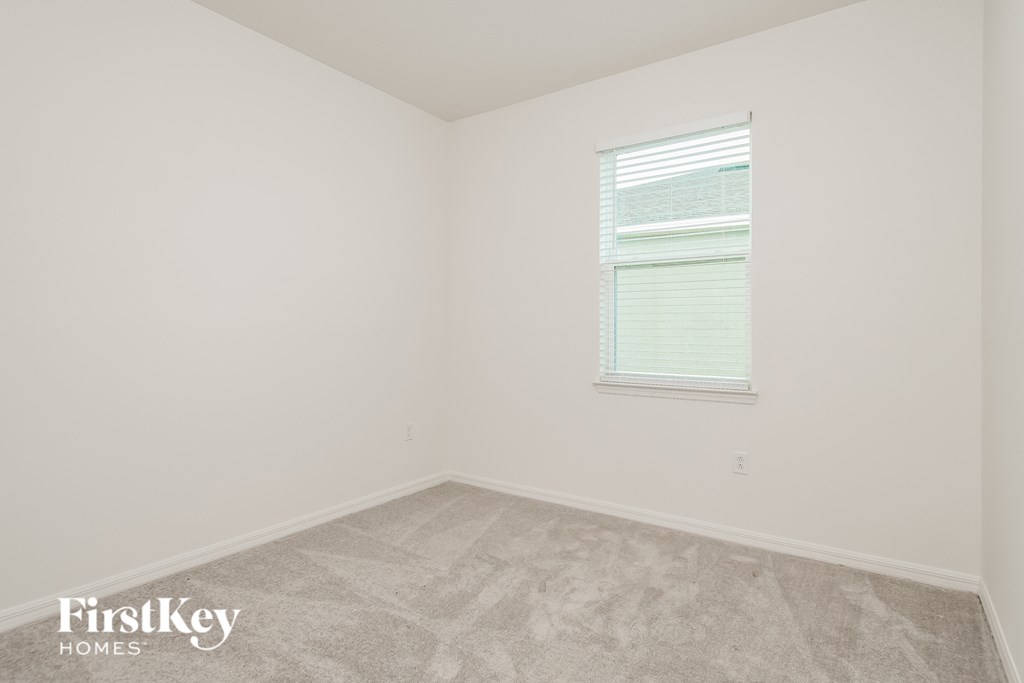 a small room with a window and white walls and flooring