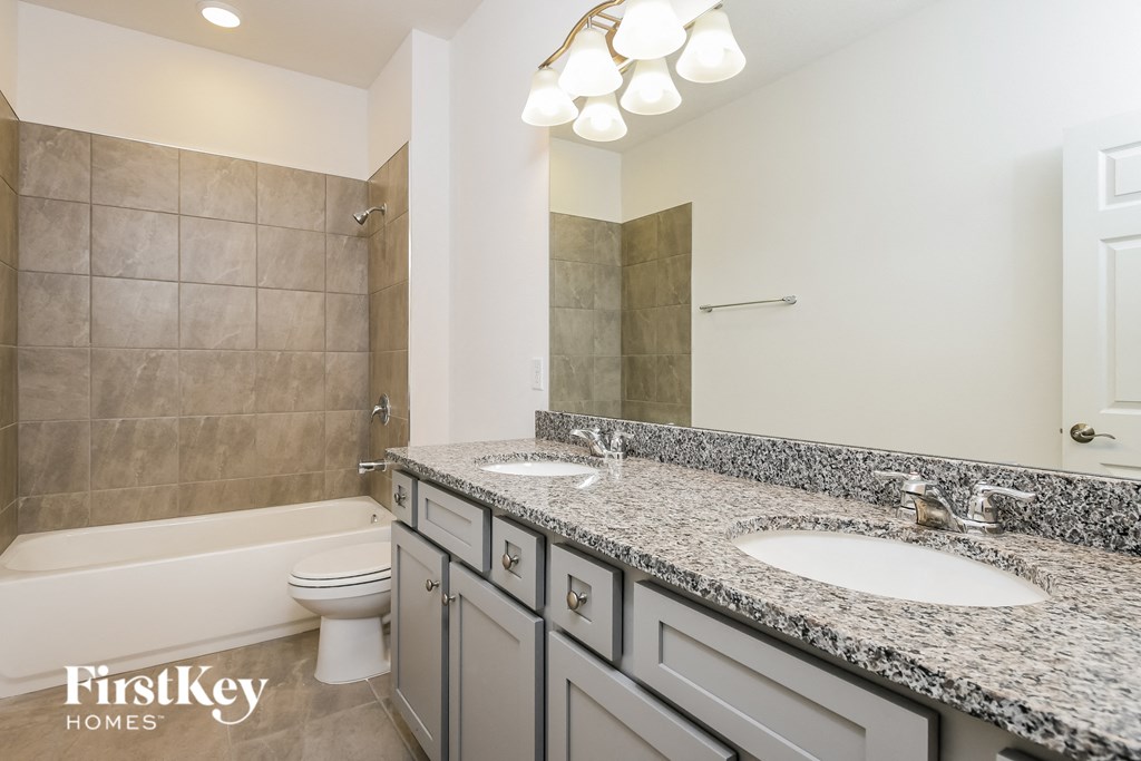 a bathroom with two sinks and a shower and a toilet