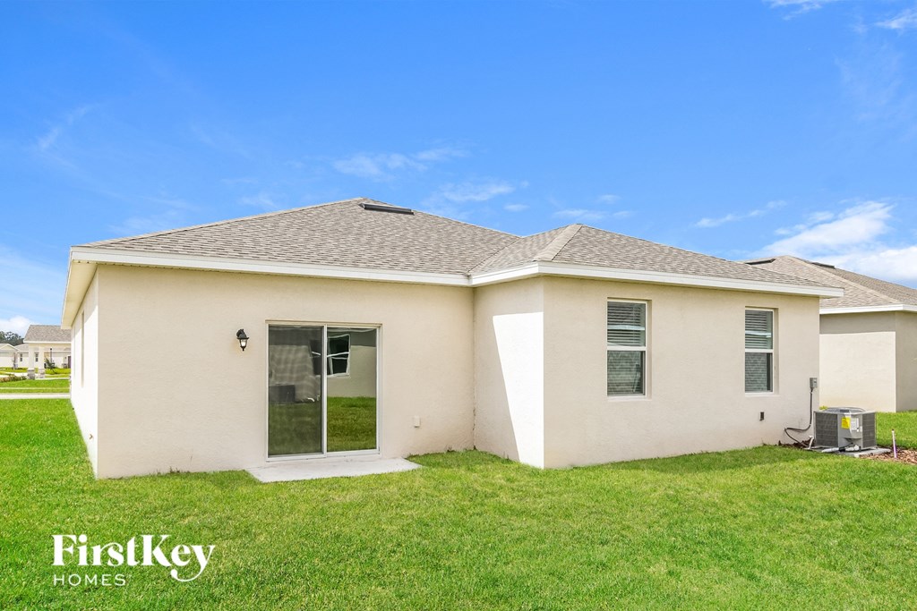 a small white house with a lawn and a blue sky
