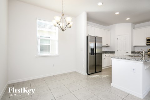 a kitchen with white cabinets and a stainless steel refrigerator