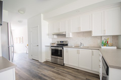 a renovated kitchen with white cabinets and stainless steel appliances