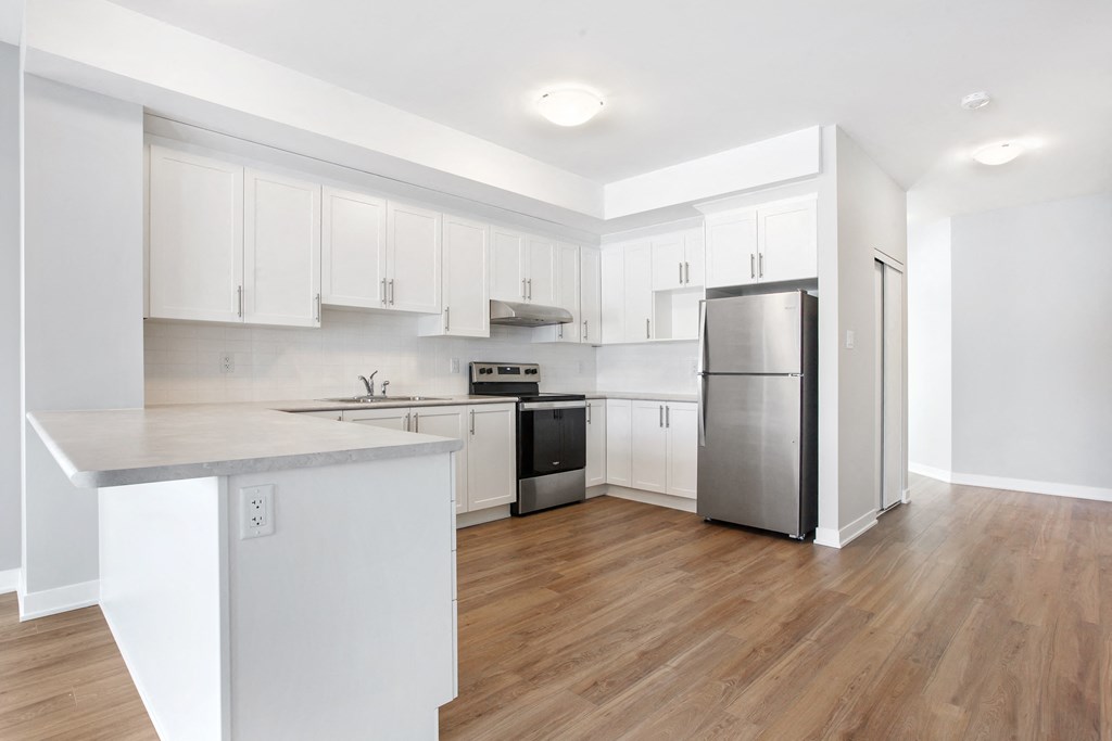 a renovated kitchen with white cabinets and a stainless steel refrigerator