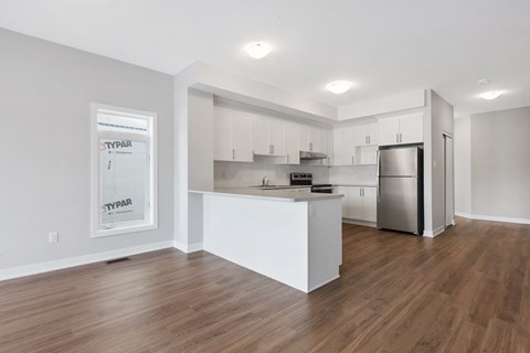 a renovated kitchen with white cabinets and a stainless steel refrigerator