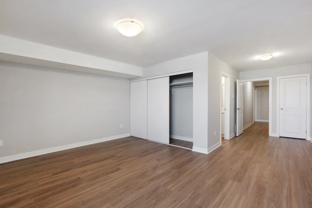 an empty living room with wood flooring and white walls