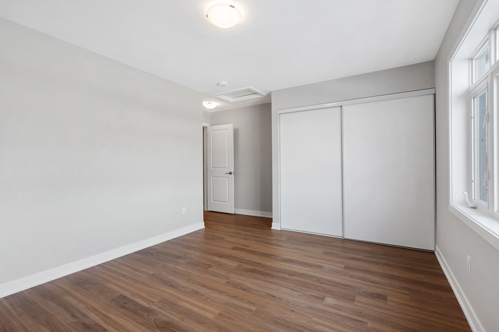 an empty living room with white walls and wood flooring