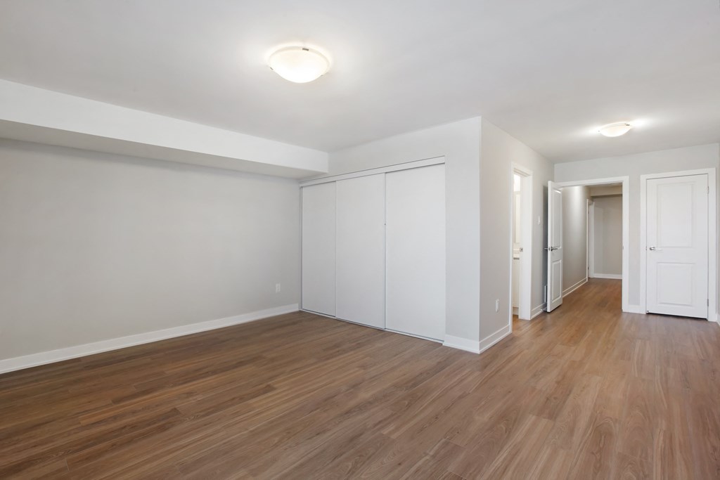 an empty living room with wood flooring and white walls