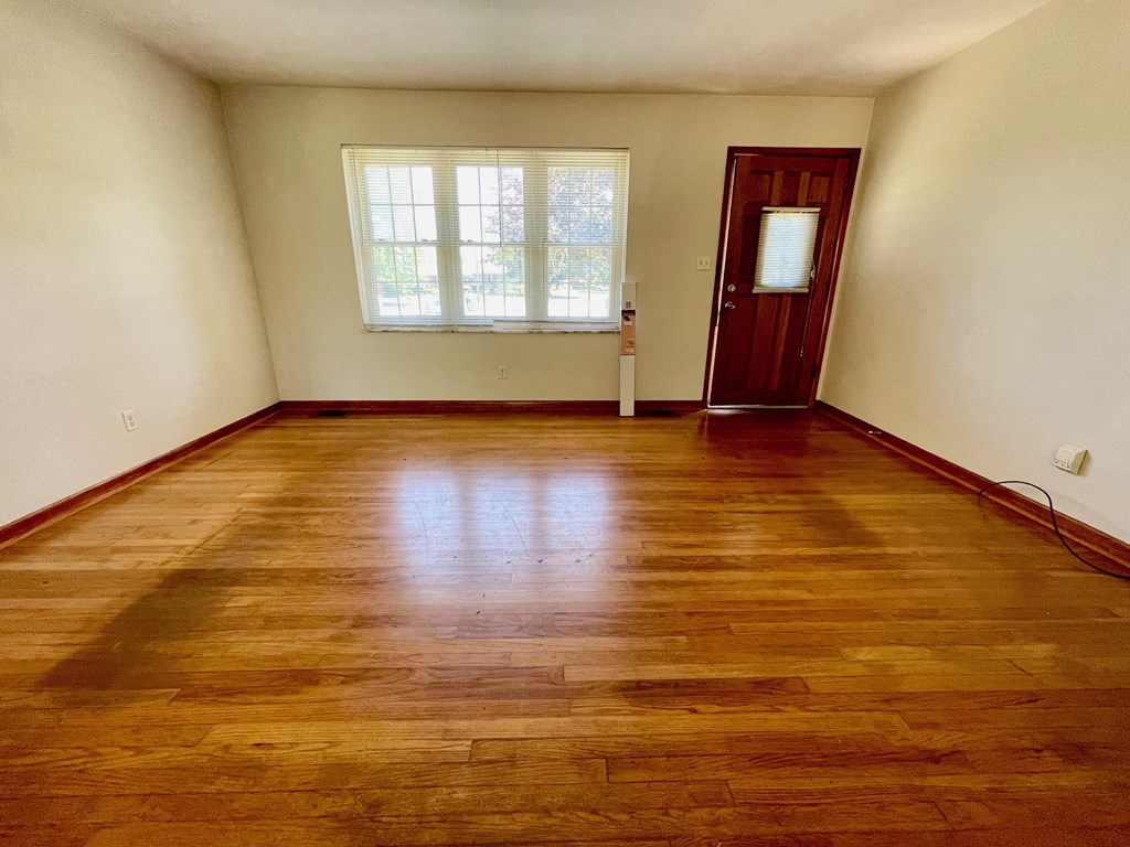 a empty room with a wooden floor and a window