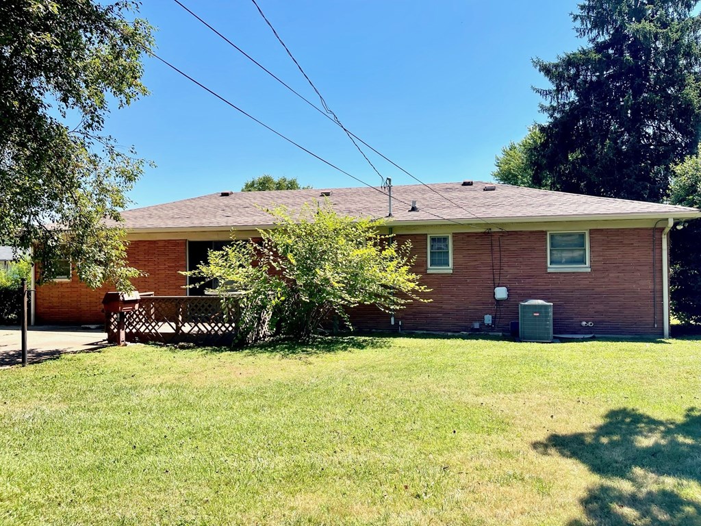a red brick house with a yard and a tree