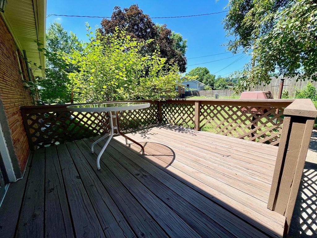a patio with a table on a wooden deck