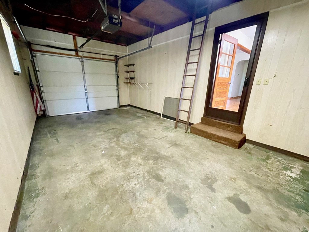 a room with a concrete floor and white walls and a window