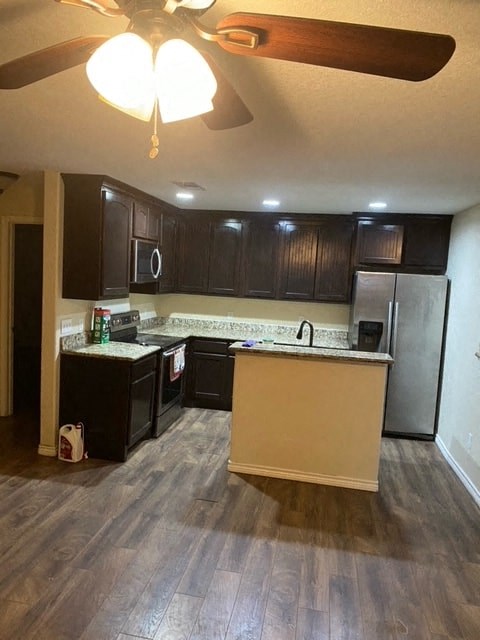 a kitchen with wooden floors and black cabinets
