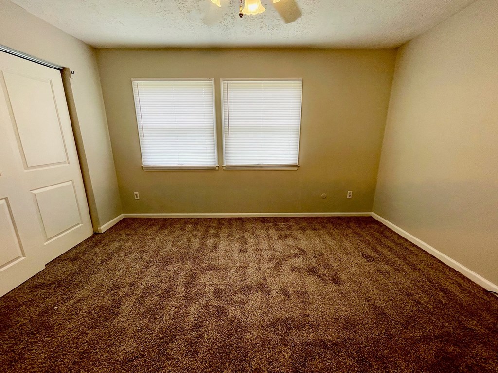 an empty room with carpet and a window