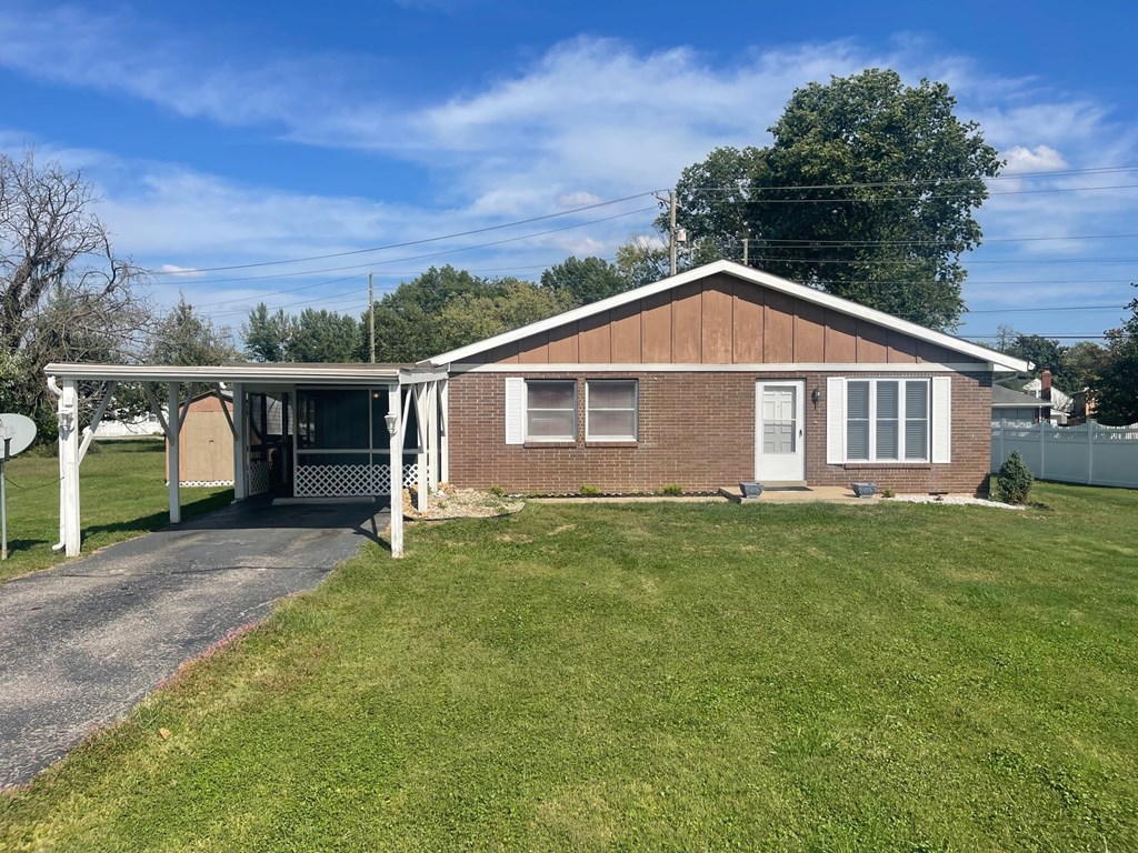 a small brick house with a covered porch and a driveway