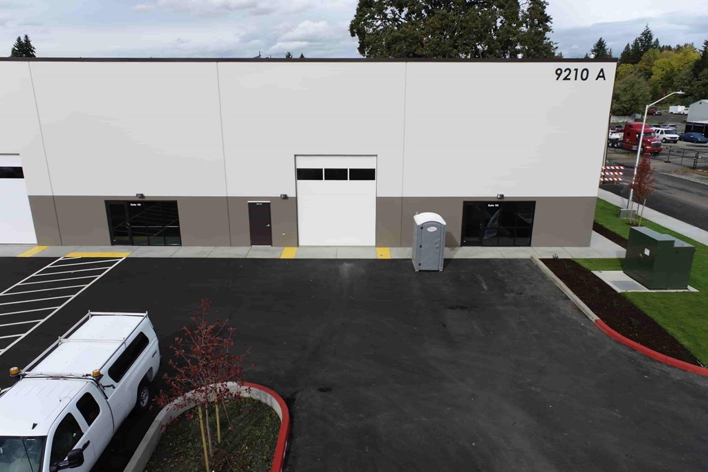a white and brown building with cars in front of it